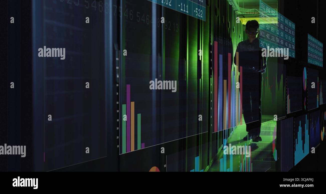 Analyzing Korean IT engineer reviewing data on tablet in server corridor, with holographic charts Stock Photo