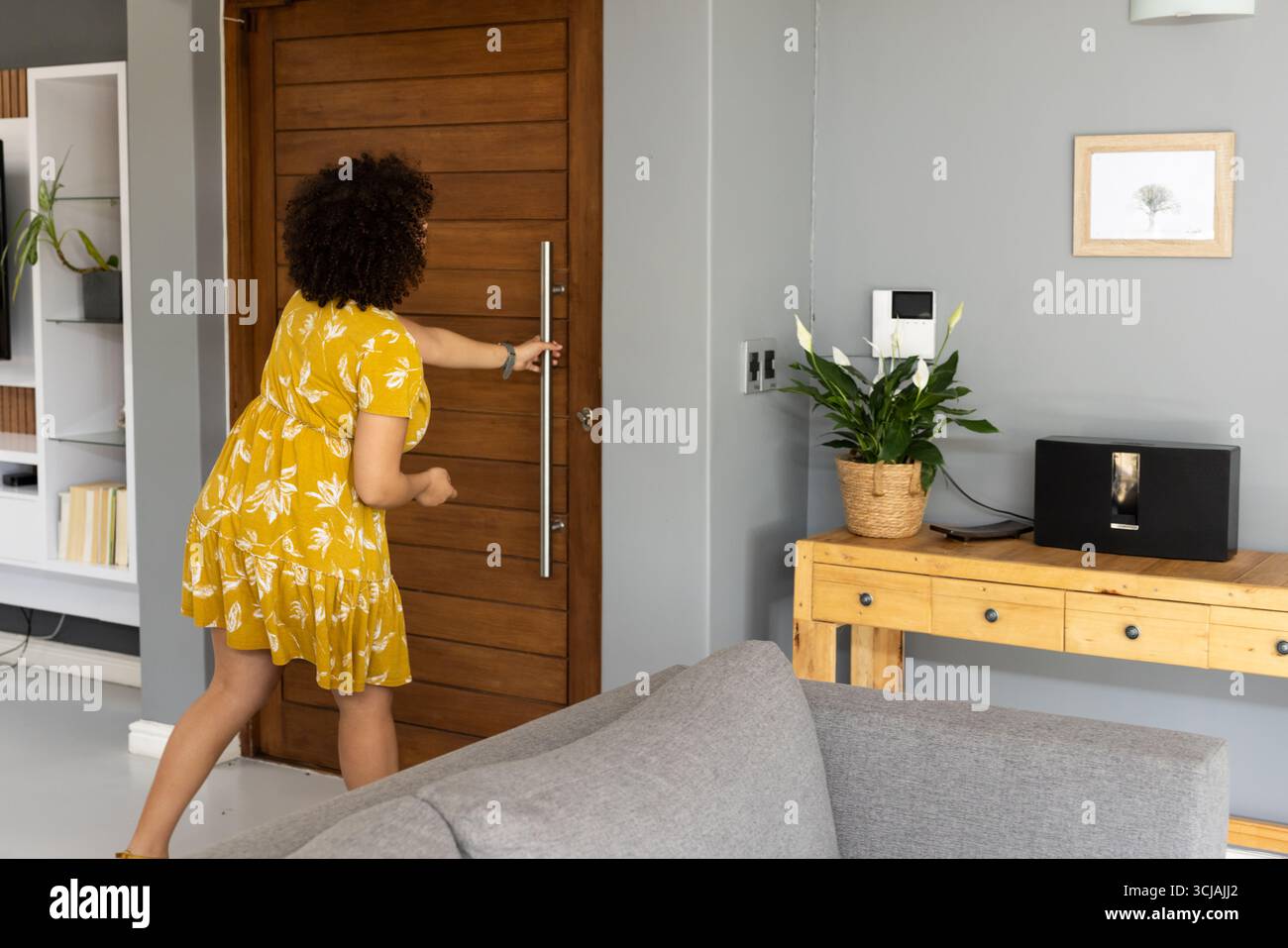 Woman hostess opening door hi-res stock photography and images - Alamy