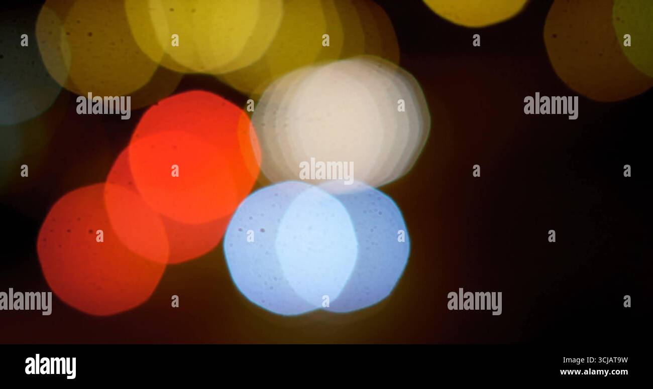 Glowing hexagonal bokeh lights overlapping against dark urban backdrop, creating abstract pattern Stock Photo