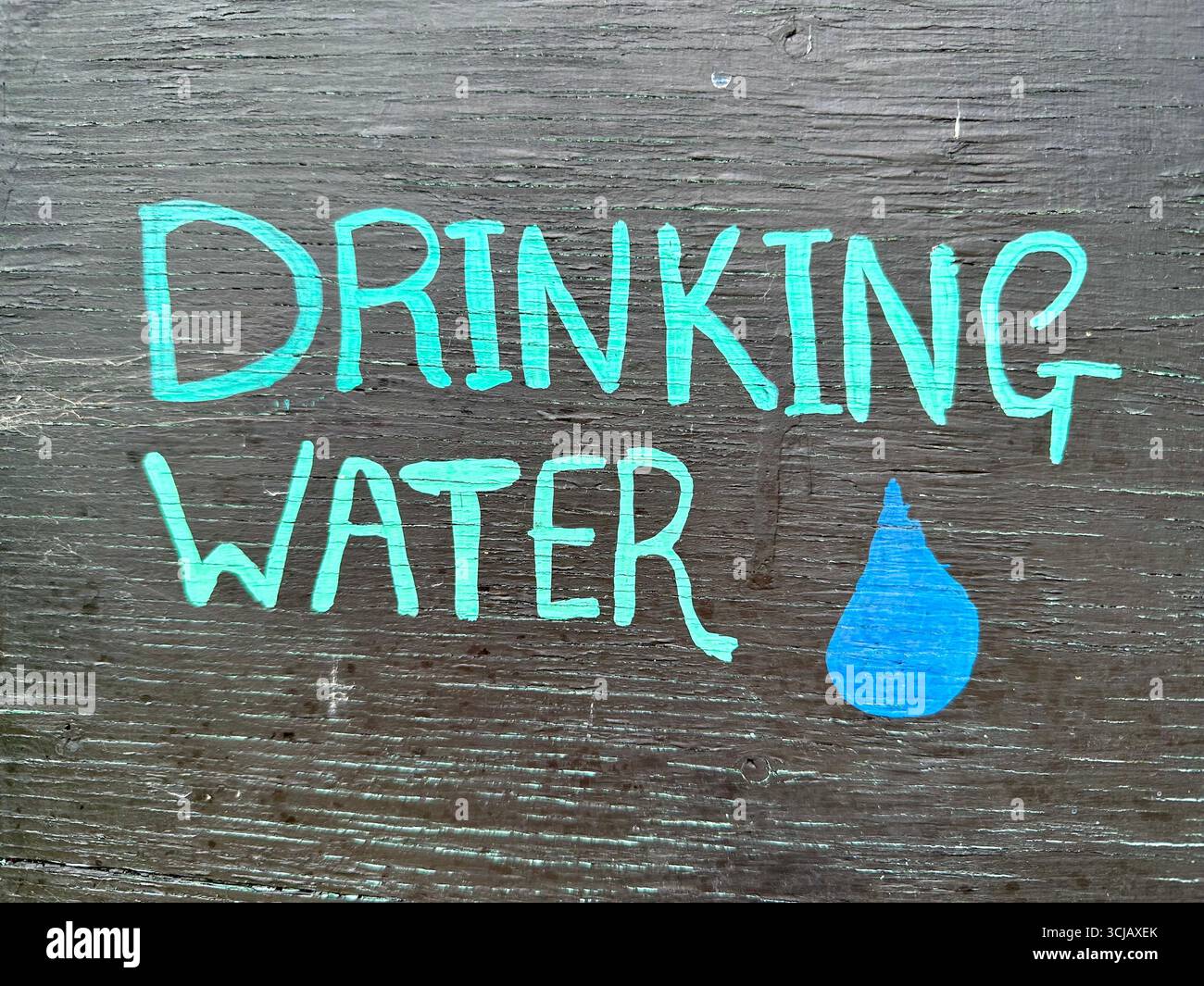 A sign saying drinking water with the image of a water drop next to it - Smartphone Captured Stock Image