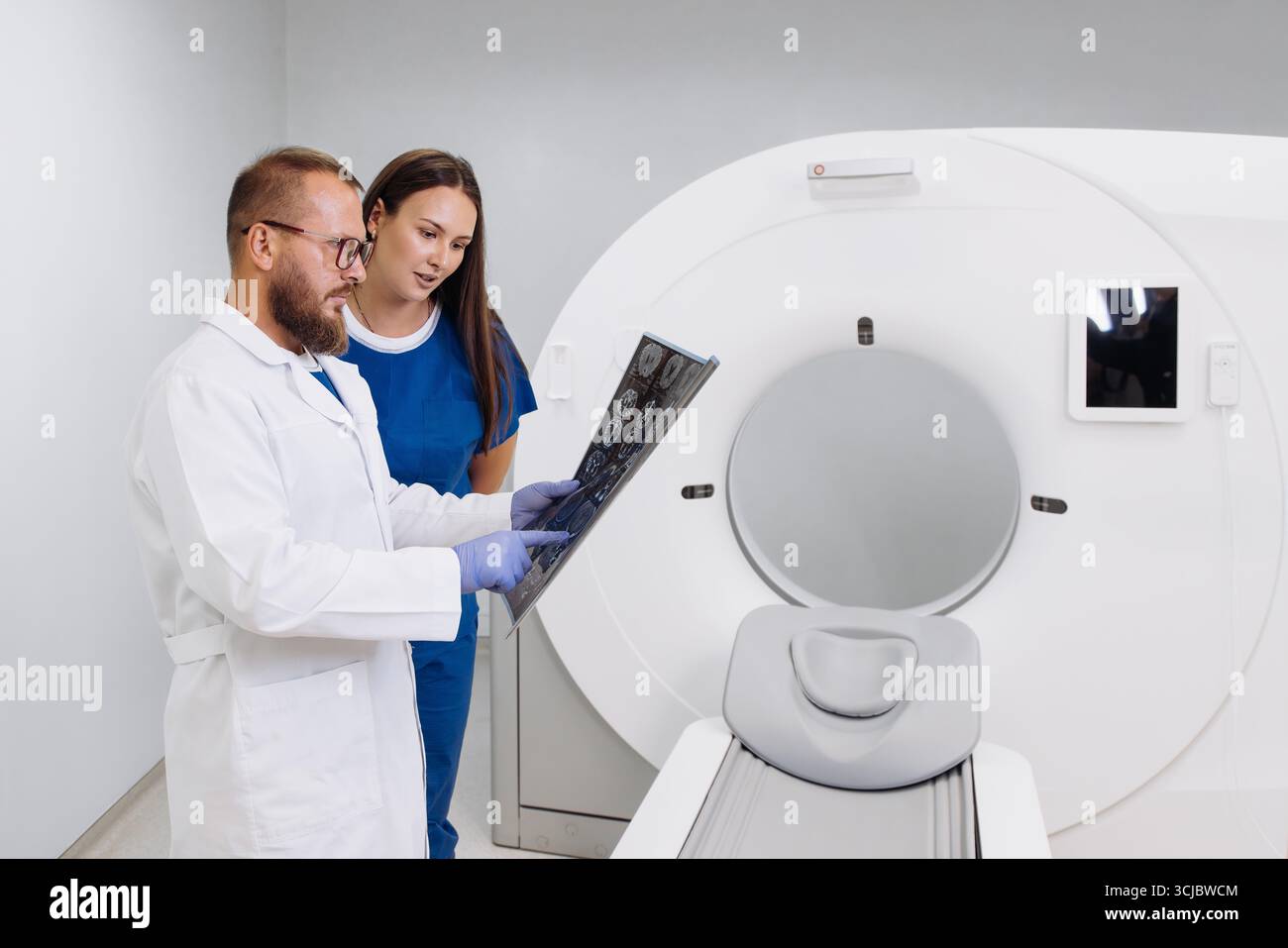 Medical professionals are closely examining CT scan images in a modern ...