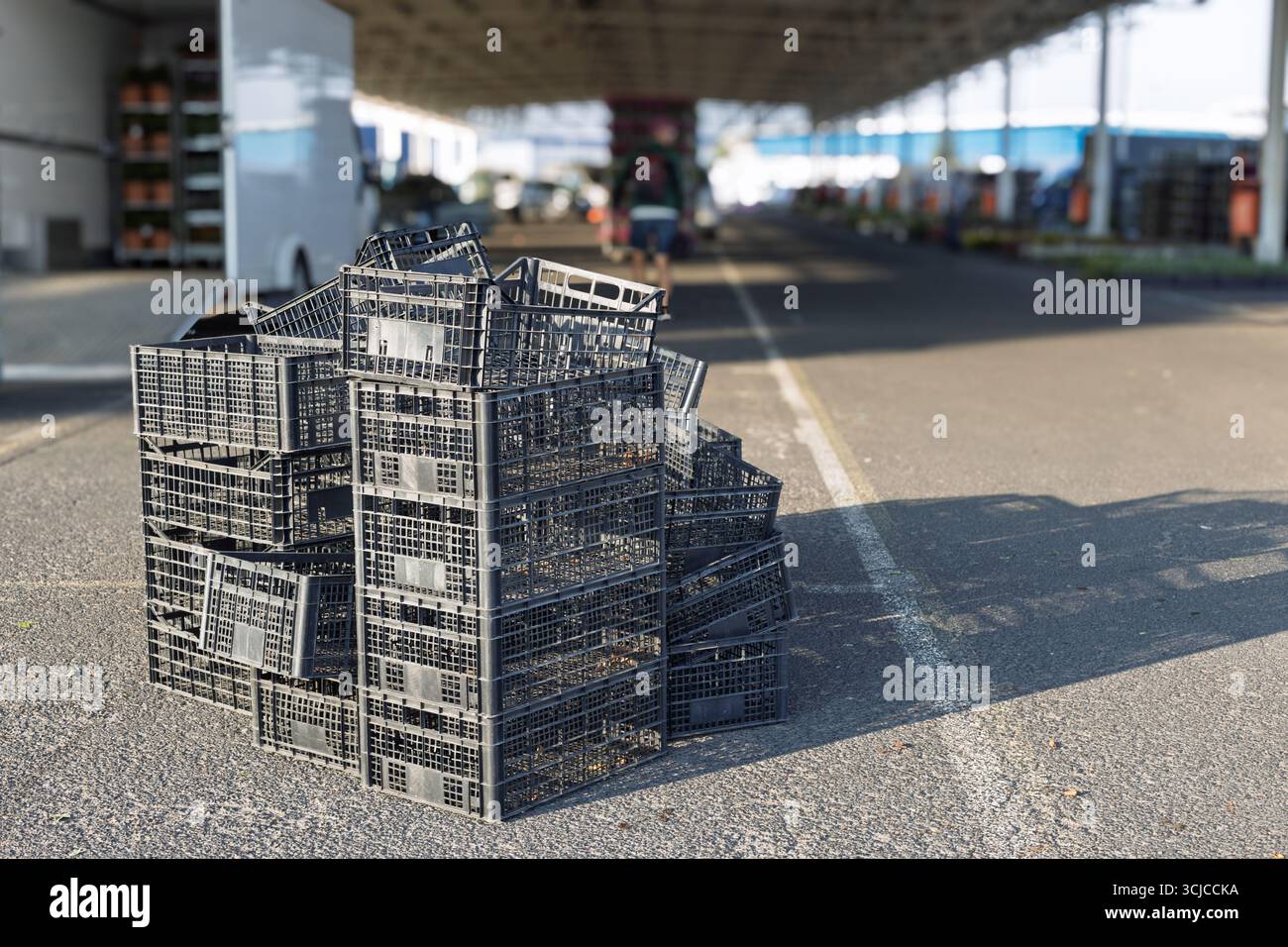 Stack of empty black plastic crates at market Stock Photo