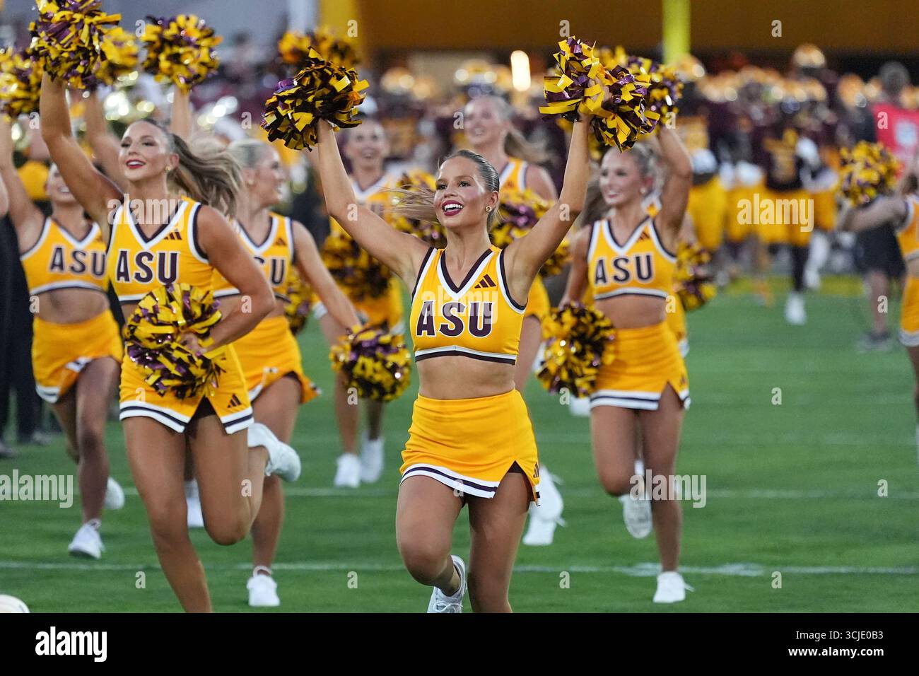 Arizona State cheerleaders run on the field prior to an NCAA football