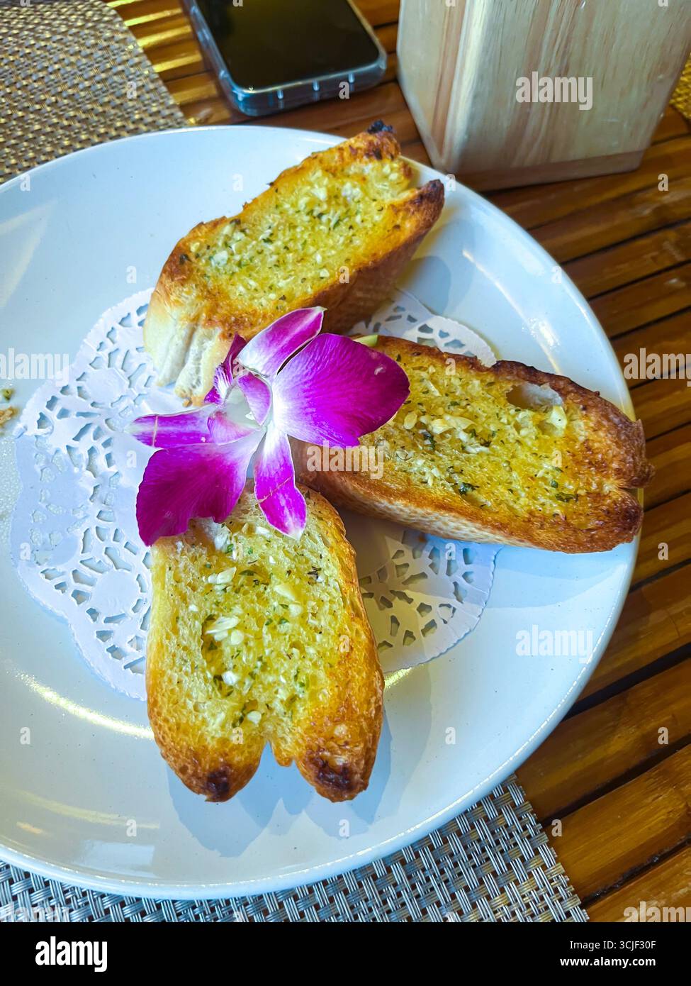 three garlic rolls with white bread on a plate, top view. Stock Photo