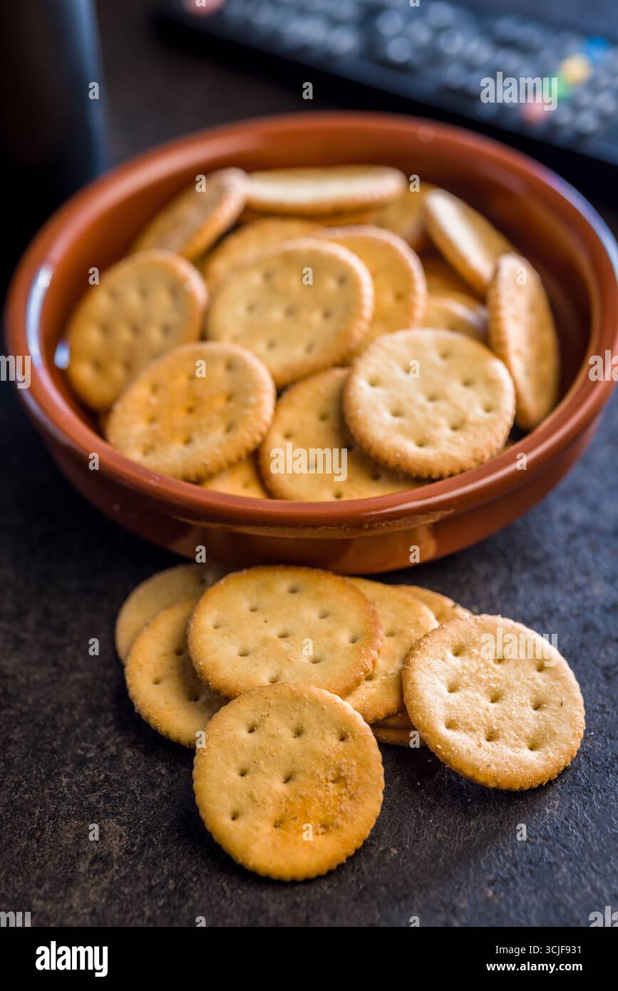 Crispy round salted crackers on a black table. Stock Photo