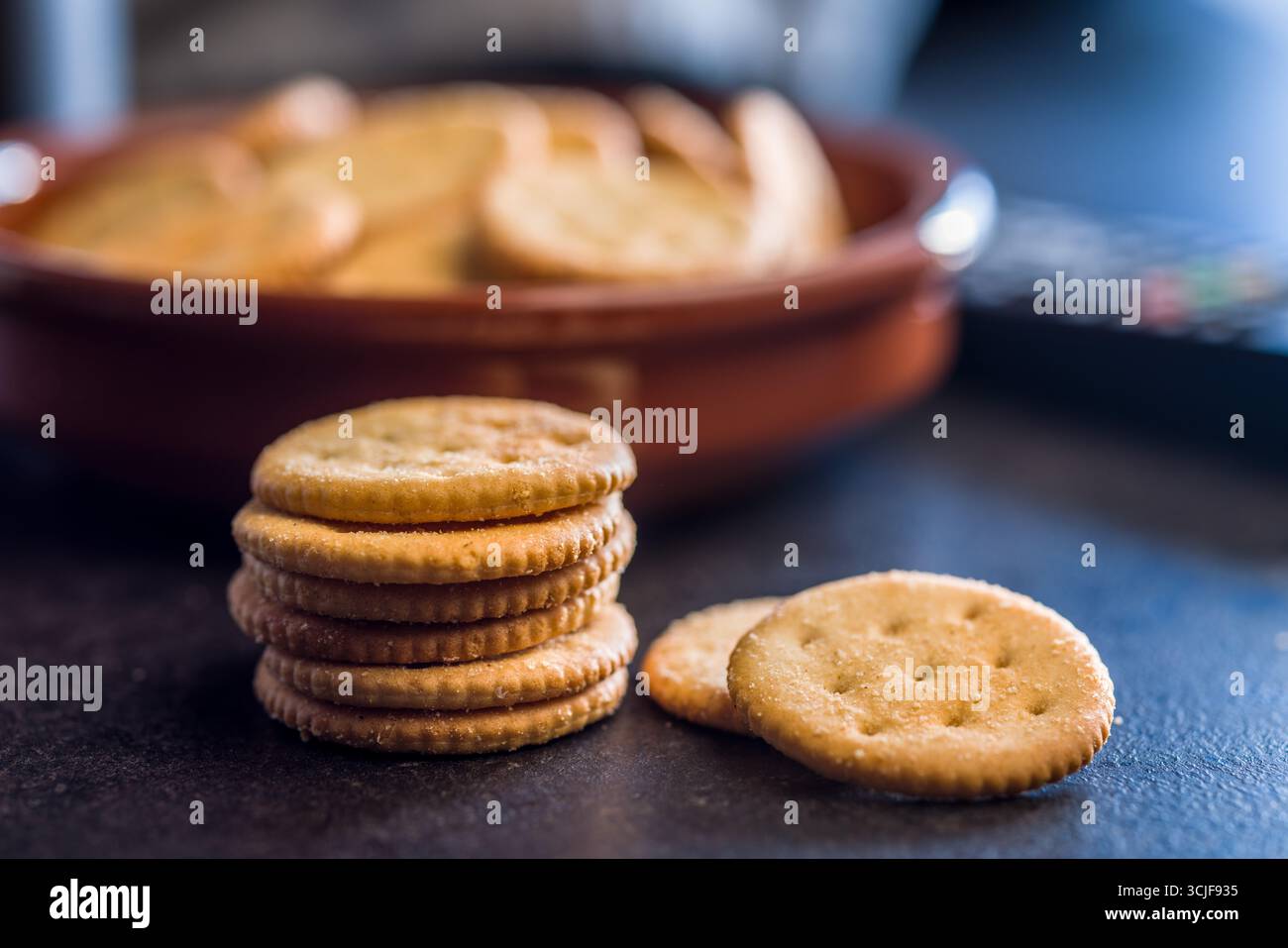 Crispy round salted crackers on a black table. Stock Photo