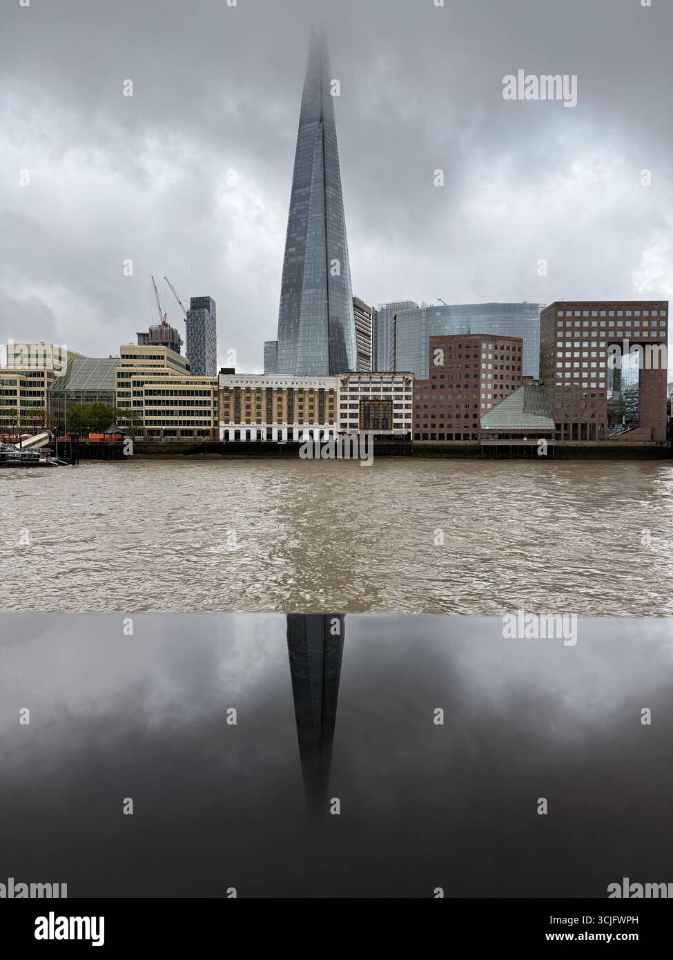 The Shard in cloud and reflected in rain water on wall, London - Smartphone Captured Stock Image