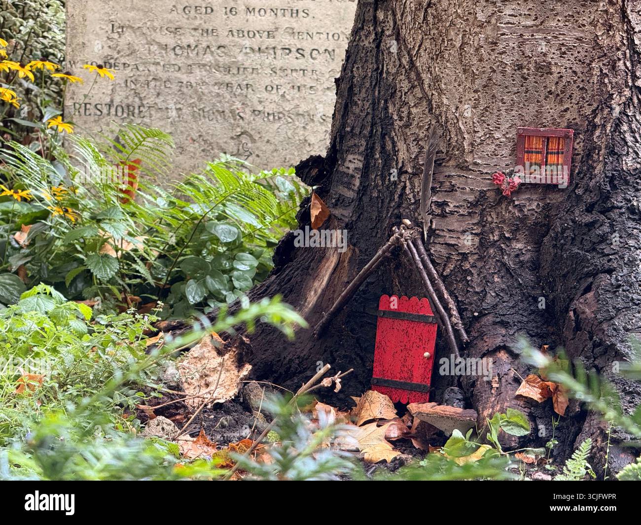 Bunhill Fields burial grounds Shoreditch, London. Fairy house amongst grave stones - Smartphone Captured Stock Image