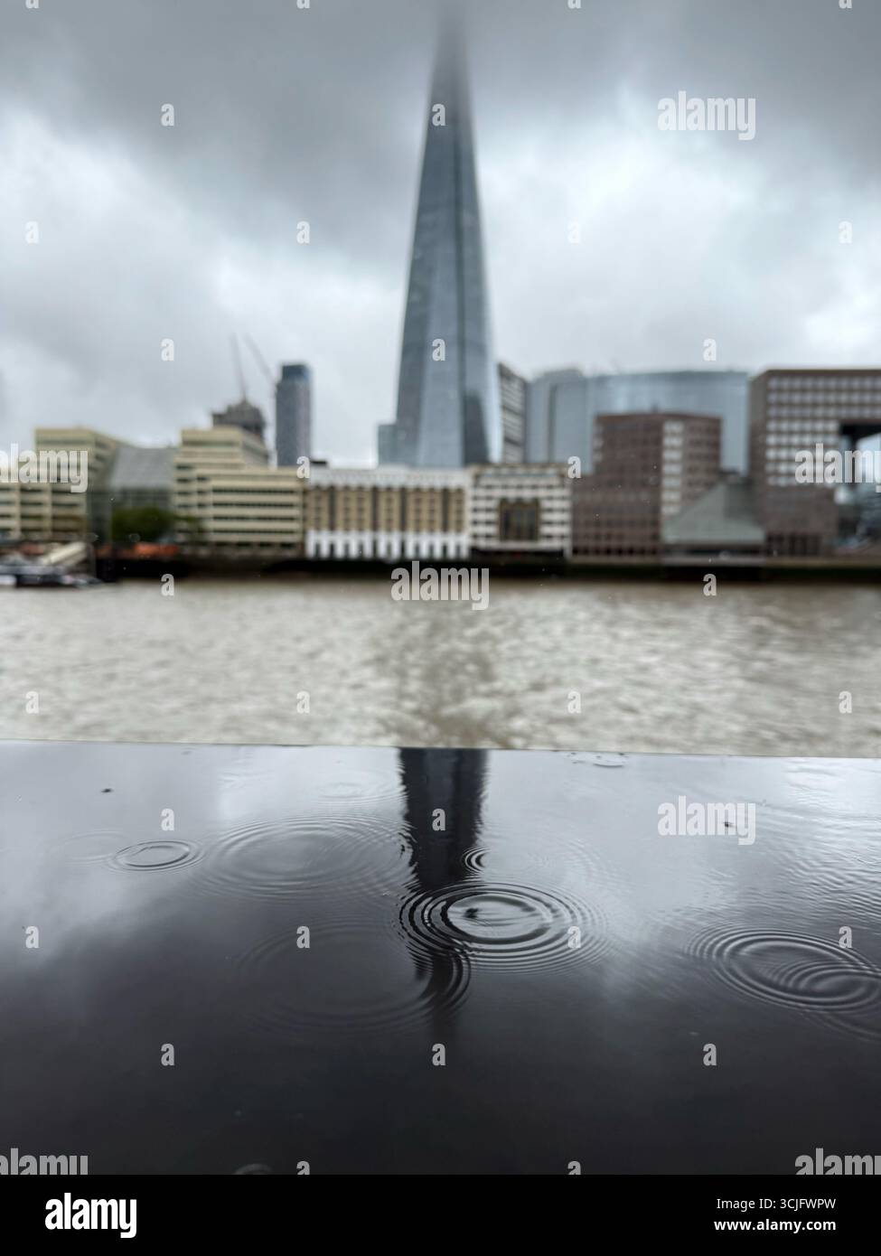 The Shard in cloud and reflected in rain water on wall, London - Smartphone Captured Stock Image