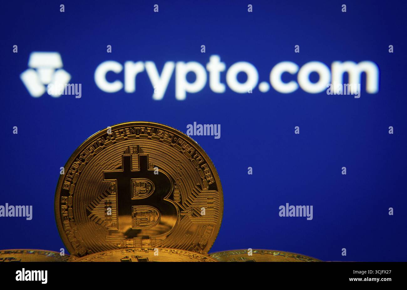 Dhaka, Bangladesh- 26 Aug 2025: Close-up of Bitcoin coins with the  Crypto.com logo visible on a screen in the background Stock Photo - Alamy