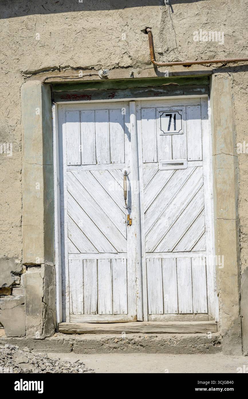 White door in mud wall to the yard, Bukhara, Uzbekistan Stock Photo