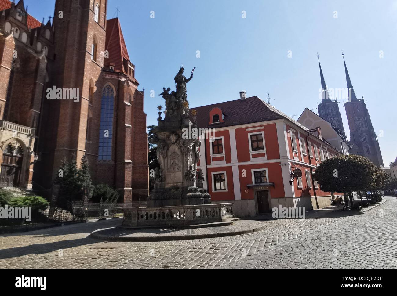 Sunlit Wrocław: Church of the Holy Cross, St. John Nepomuk statue,  Cathedral of St. John the Baptist towers in view on Cathedral Road, Ostrów Tumski. - Smartphone Captured Stock Image