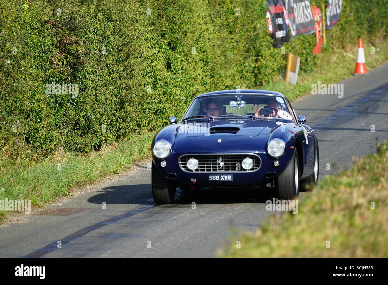 Vintage Sports Car Driving Along a Scenic Country Road in Daylight ...