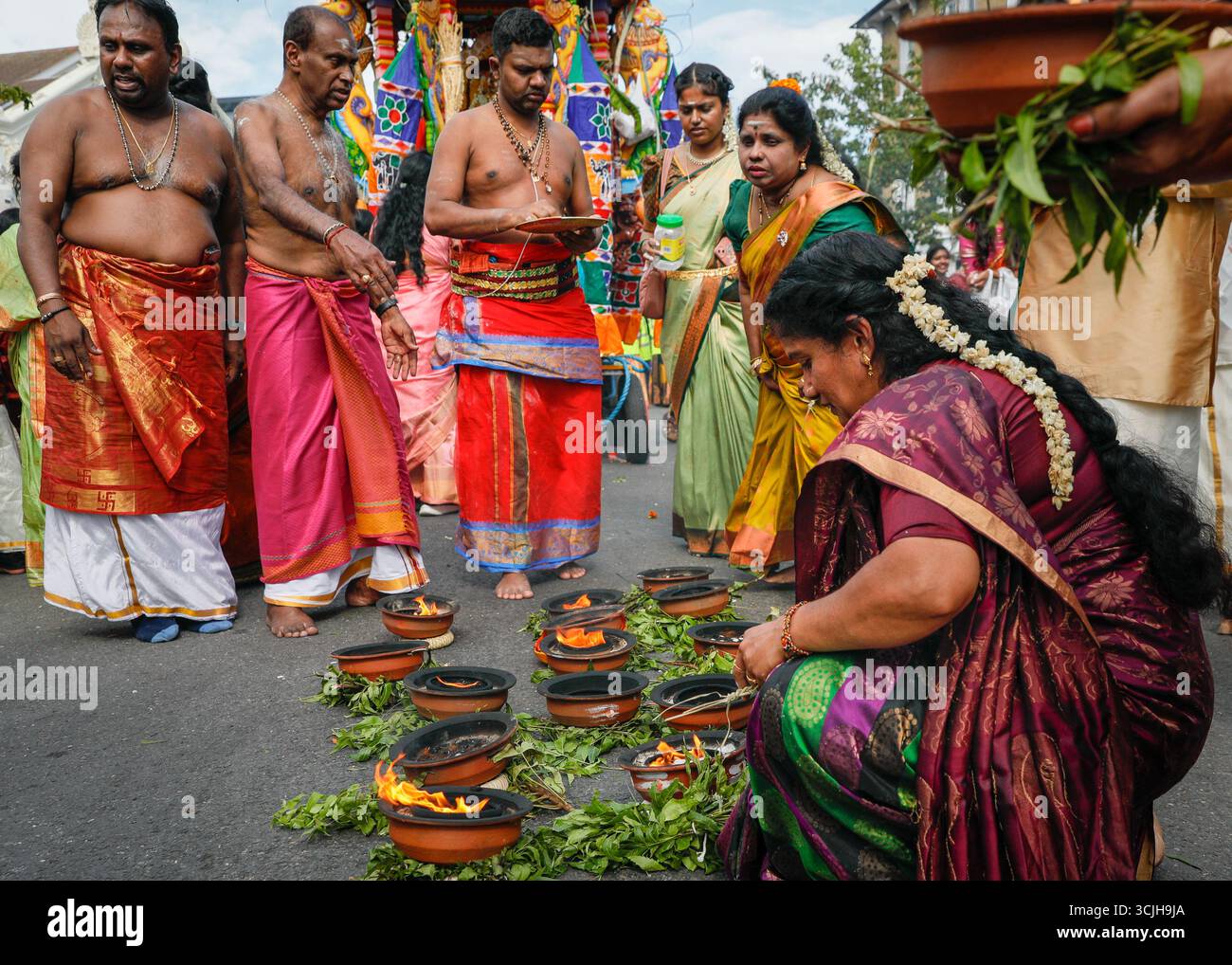 London, UK. 07th Sep, 2025. At the end of the procession, women put down their burning incense containers behind the chariots by the temple, to pay their respects. Hindu devotees, mostly from the Tamil community, take part in the annual Chariot Festival with a vibrant and cheerful procession from the Sivan Kovil Temple through the streets of Lewisham. The deities of Ganesha and Lord Shiva are carried in decorated chariots. Devotees make offerings of milk, burning incense, coconuts or fruit. Credit: Imageplotter/Alamy Live News Stock Photo