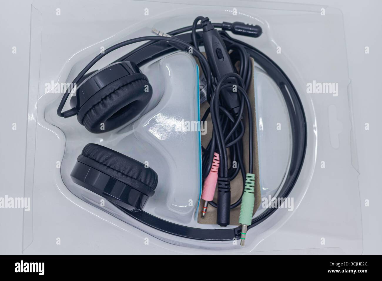 Black Wired Headset with Microphone in Plastic Packaging on White Studio Background. Stock Photo