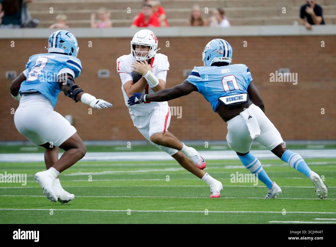 Houston quarterback Conner Weigman, center, looks for a hole between ...