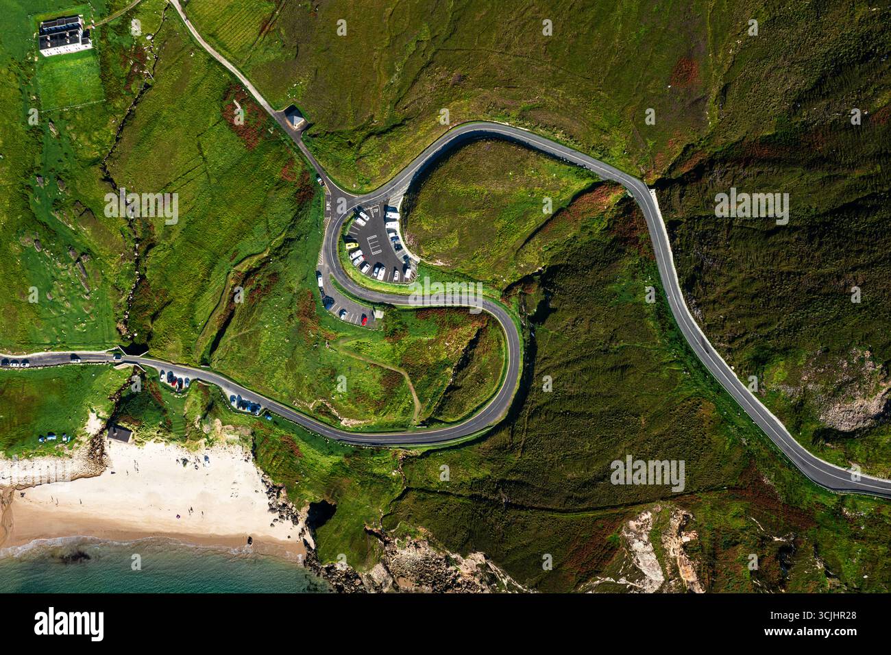 Aerial top down view of winding S shaped road and parking lot at Keem Beach on Achill Island in Ireland Stock Photo