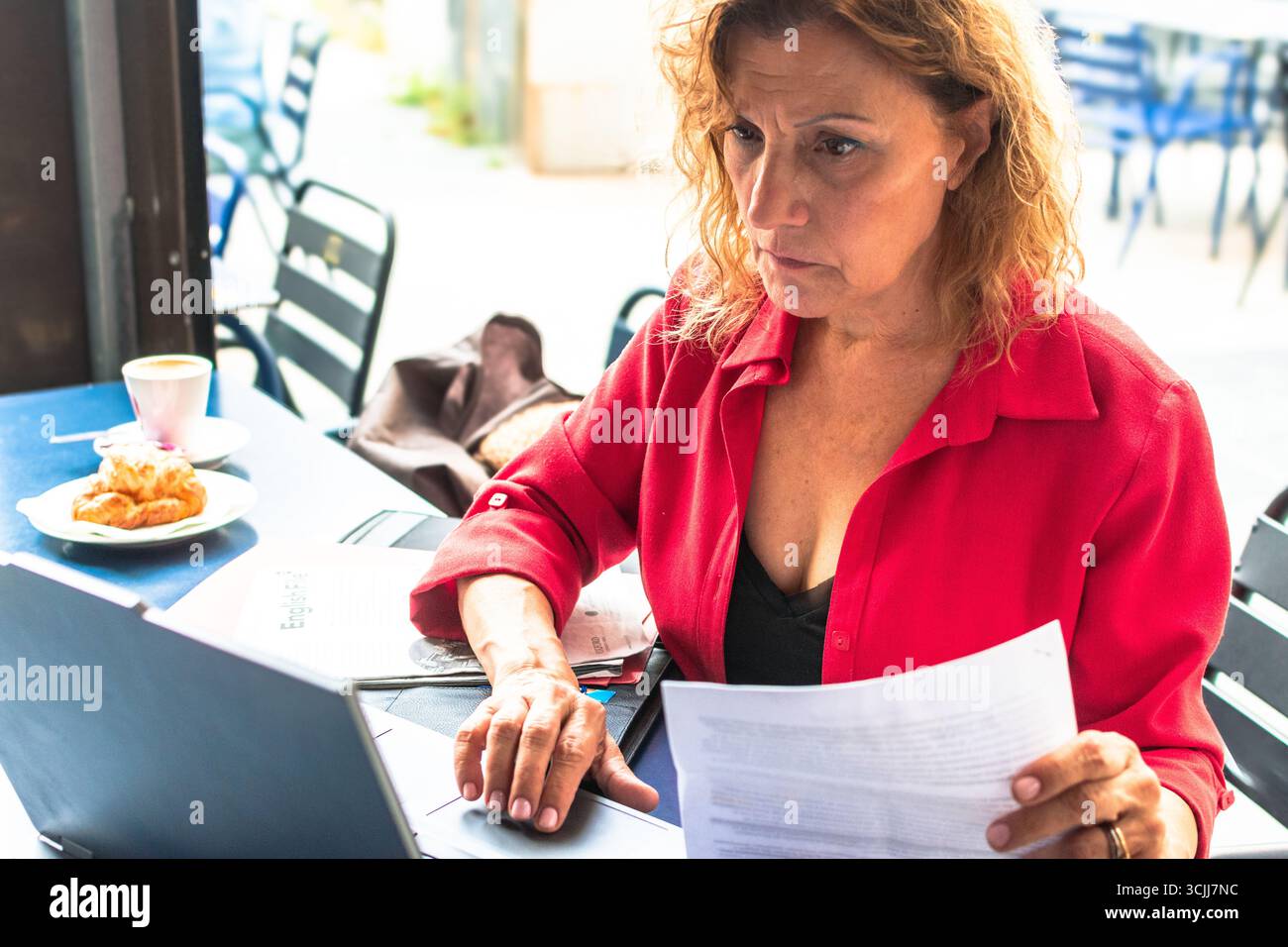 Focused senior executive woman working at cafe Stock Photo