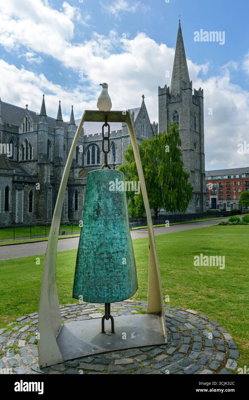 The Liberty Bell, a sculpture by Vivienne Roche, with a gull perched on it.  St Patricks Park, Dublin, Ireland.  Saint Patrick’s Cathedral behind. Stock Photo