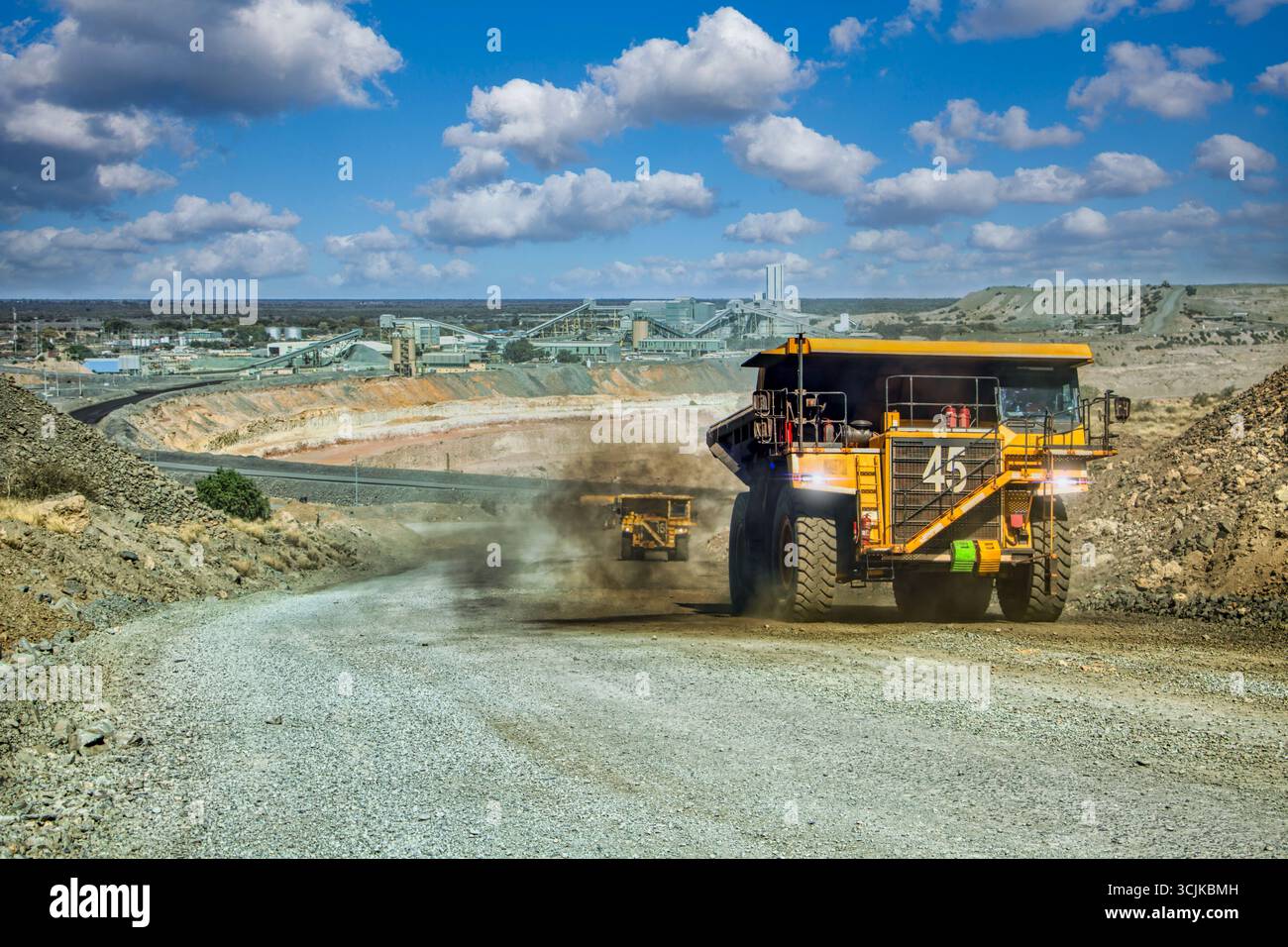 mining trucks with kimberlite driving on gravel road, open pit mine, large industrial operation to extract diamonds, Stock Photo
