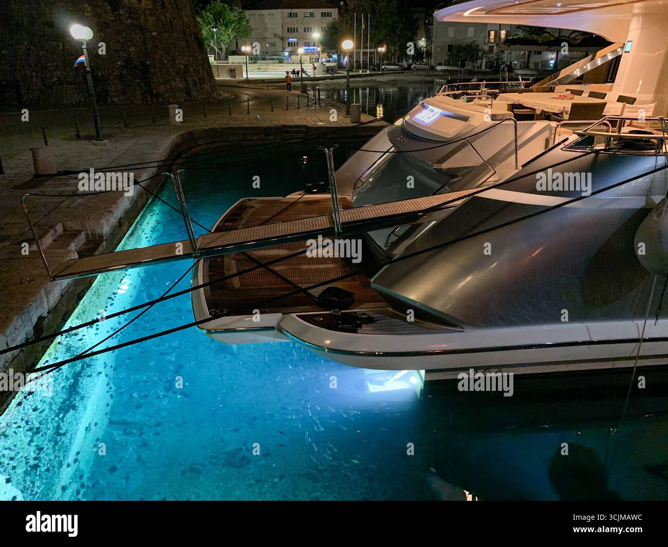 Korcula, Croatia: Luxury motor yacht, stunning submarine underwater lights illuminating the blue turquoise waters, under water boat illumination - Smartphone Captured Stock Image
