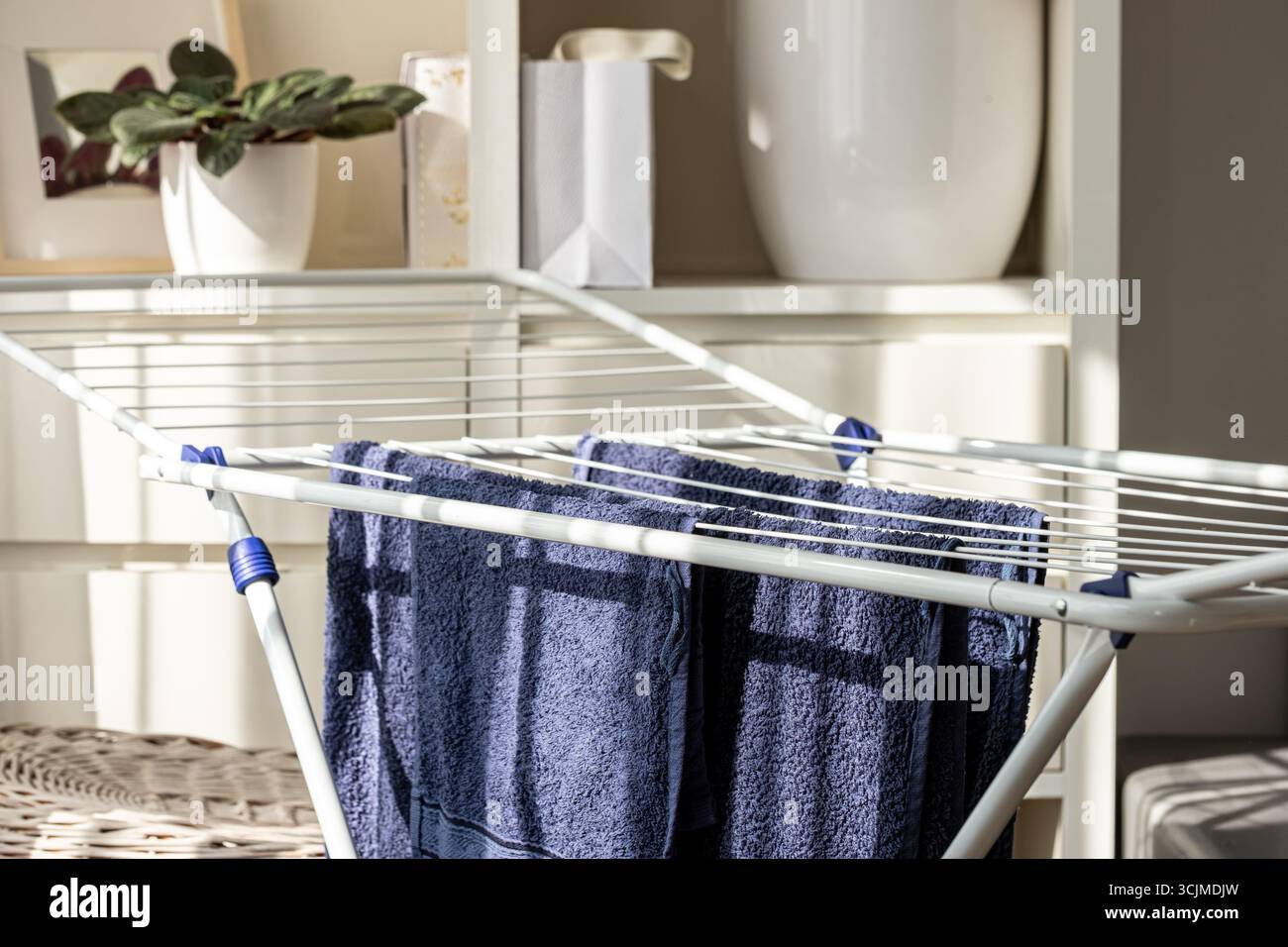 Neatly organized blue towels hang on a drying rack in a cozy indoor space, highlighting their soft texture and fresh appearance in a practical arrange Stock Photo