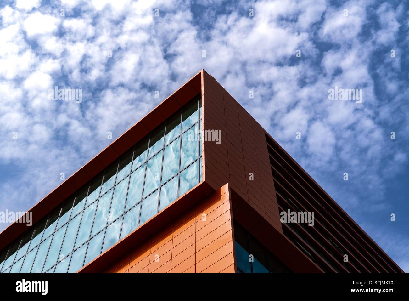 Modern office building with geometric glass facade featuring open ...