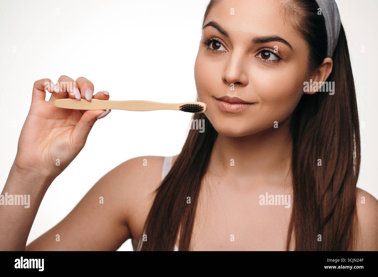Beautiful dark haired woman holding toothbrush in studio Stock Photo