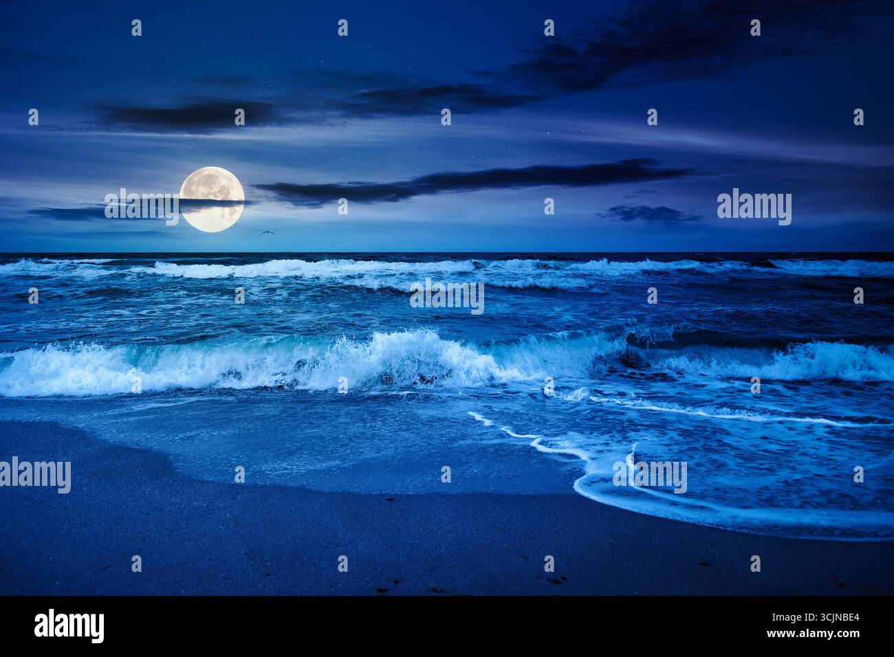 stormy beach scenery with waves splash on sand shore under scenic clouds on the sky at night. dark moody nature background for travel. scenic view of Stock Photo
