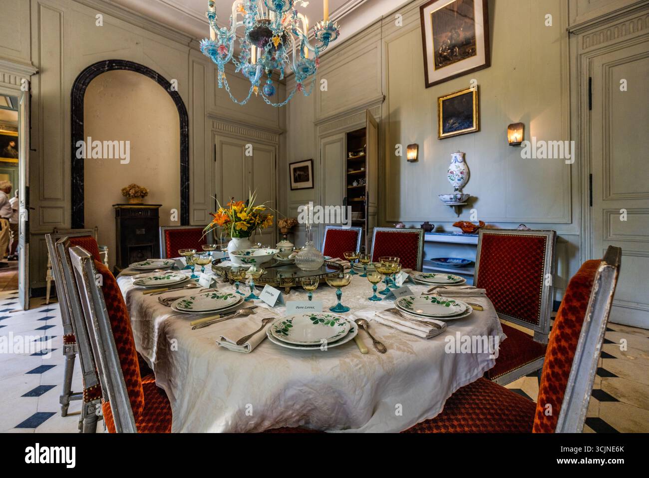 Dining room at Domaine de Nohant. This is where George Sand gathered her guests around her. Even today, the table is still set as if for dinner. A Venetian glass chandelier hangs above the table where guests such as Franz Liszt, Honoré de Balzac, Gustave Flaubert and Eugène Delacroix, as well as her partner Frédéric Chopin, once sat. Place Sainte-Anne, Nohant-Vic, Centre-Val de Loire, France Stock Photo