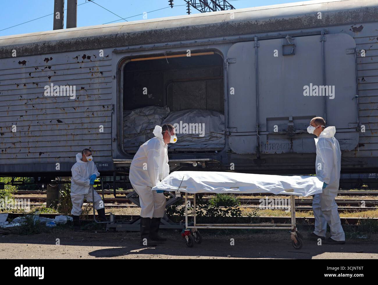 Experts of the Odesa Regional Bureau of Forensic Medical Examination wearing protective suits load the repatriated bodies of perished Ukrainian military personnel in body bags into a refrigerator carriage after forensic experts took samples of genetic material for DNA profiling and further examination, Odesa region, Ukraine, September 4, 2025. (Photo by Nina Liashonok/Ukrinform) Stock Photo
