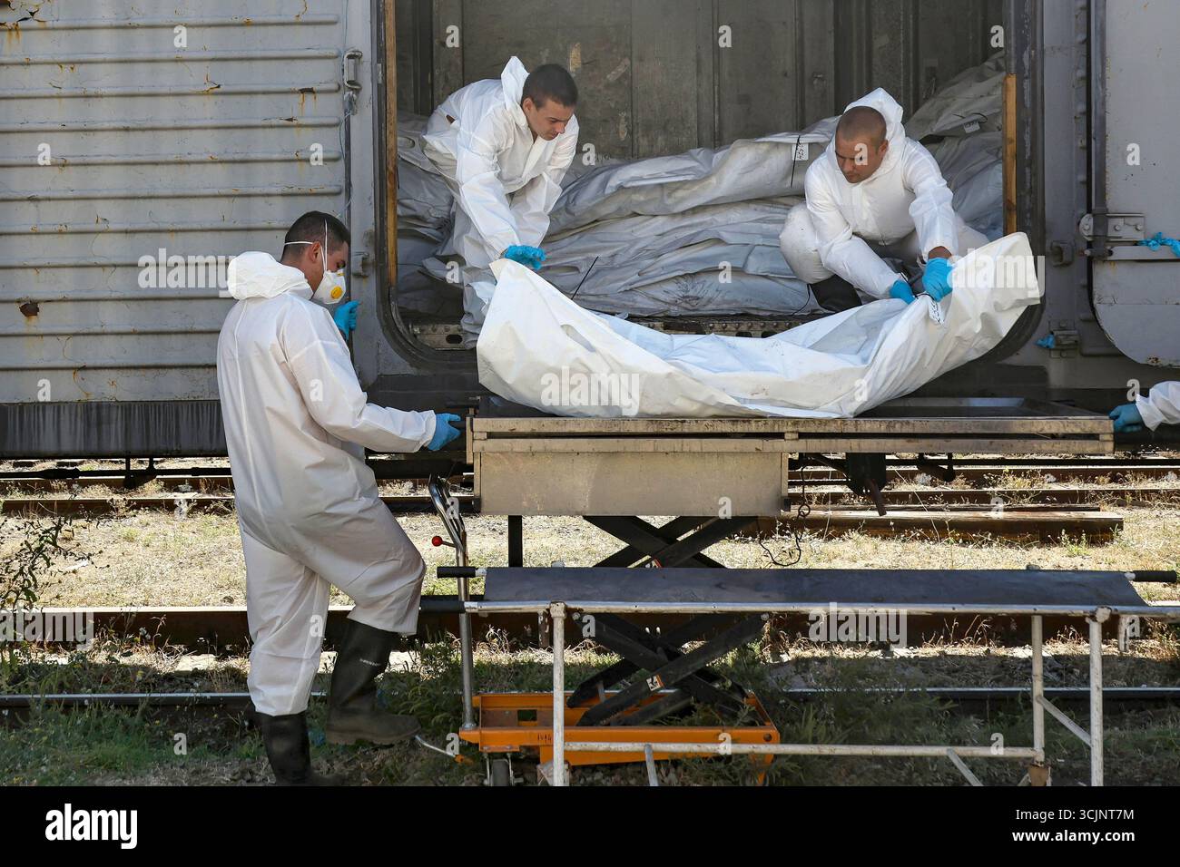 Experts of the Odesa Regional Bureau of Forensic Medical Examination wearing protective suits load the bodies of repatriated Ukrainian military personnel in body bags into a refrigerator carriage after forensic experts took samples of genetic material for DNA profiling and further examination, Odesa region, Ukraine, September 4, 2025. (Photo by Nina Liashonok/Ukrinform) Stock Photo