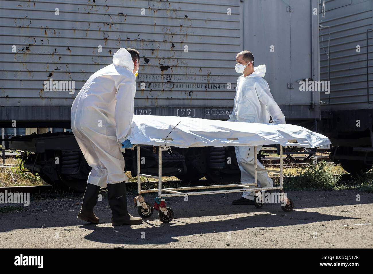 Experts of the Odesa Regional Bureau of Forensic Medical Examination wearing protective suits load the repatriated bodies of perished Ukrainian military personnel in body bags into a refrigerator carriage after forensic experts took samples of genetic material for DNA profiling and further examination, Odesa region, Ukraine, September 4, 2025. (Photo by Nina Liashonok/Ukrinform) Stock Photo