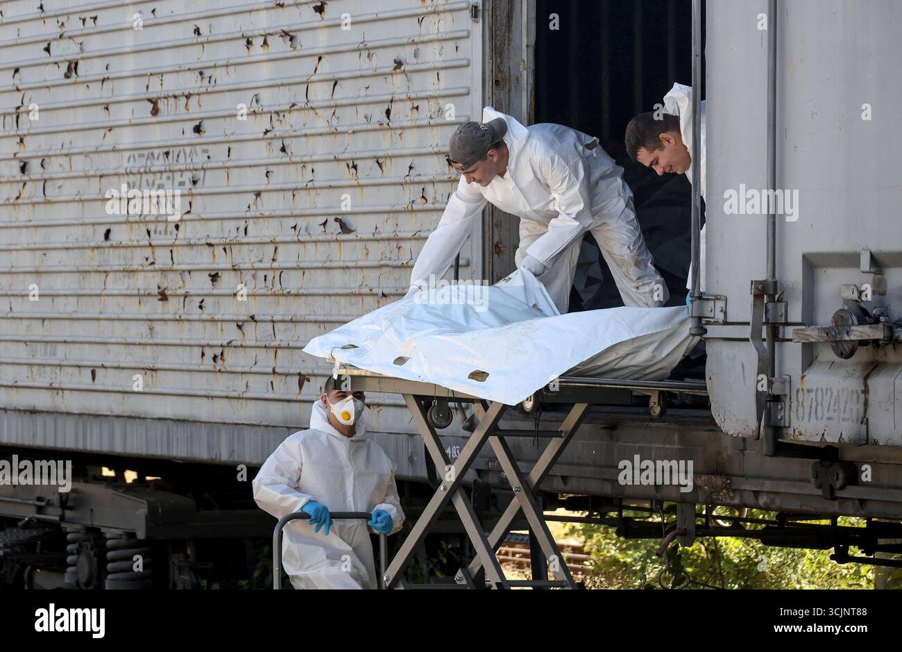 Experts of the Odesa Regional Bureau of Forensic Medical Examination wearing protective suits load the repatriated bodies of perished Ukrainian military personnel in body bags into a refrigerator carriage after forensic experts took samples of genetic material for DNA profiling and further examination, Odesa region, Ukraine, September 4, 2025. (Photo by Nina Liashonok/Ukrinform) Stock Photo