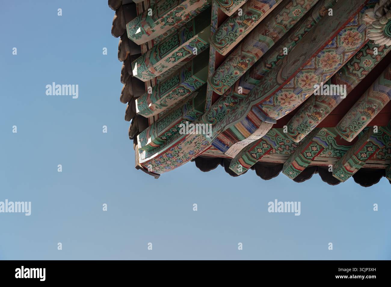 The roof of a Buddhist temple against the blue sky in Busan, Korea Stock Photo