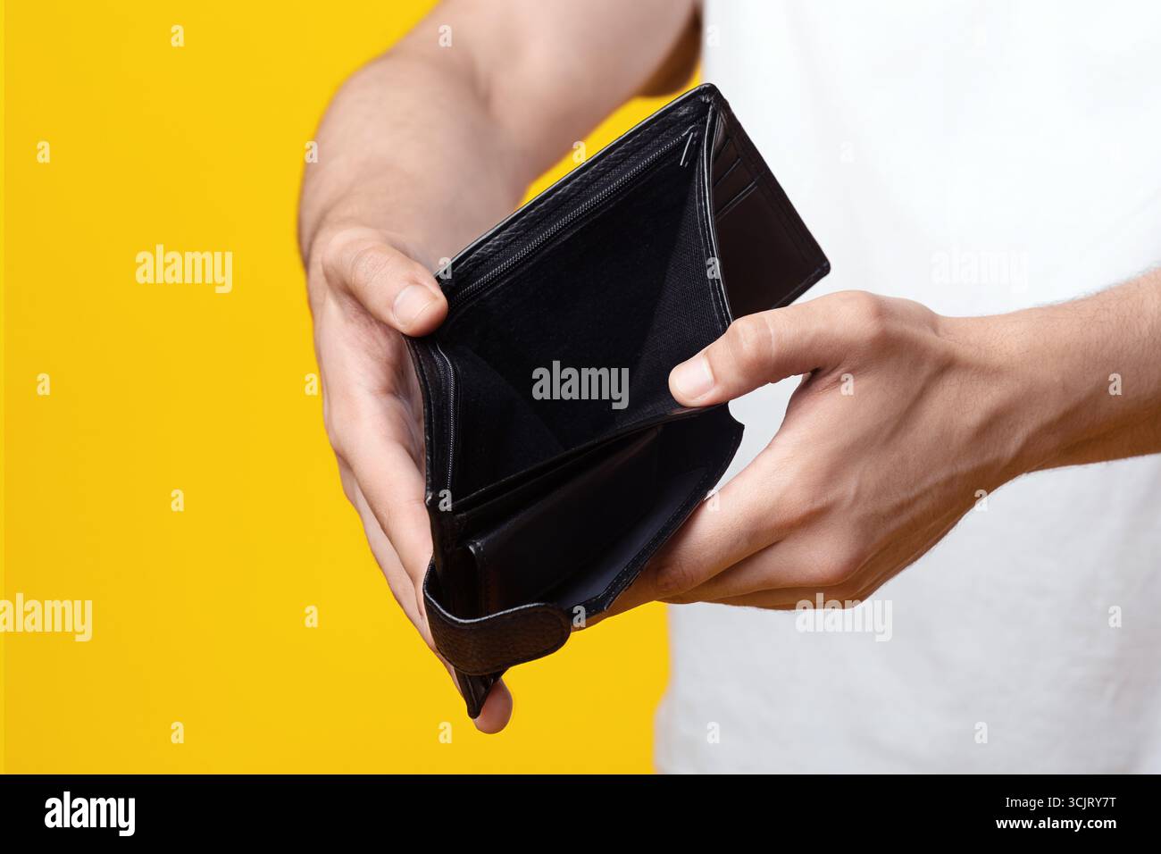 Unrecognizable man showing empty wallet at studio, closeup Stock Photo