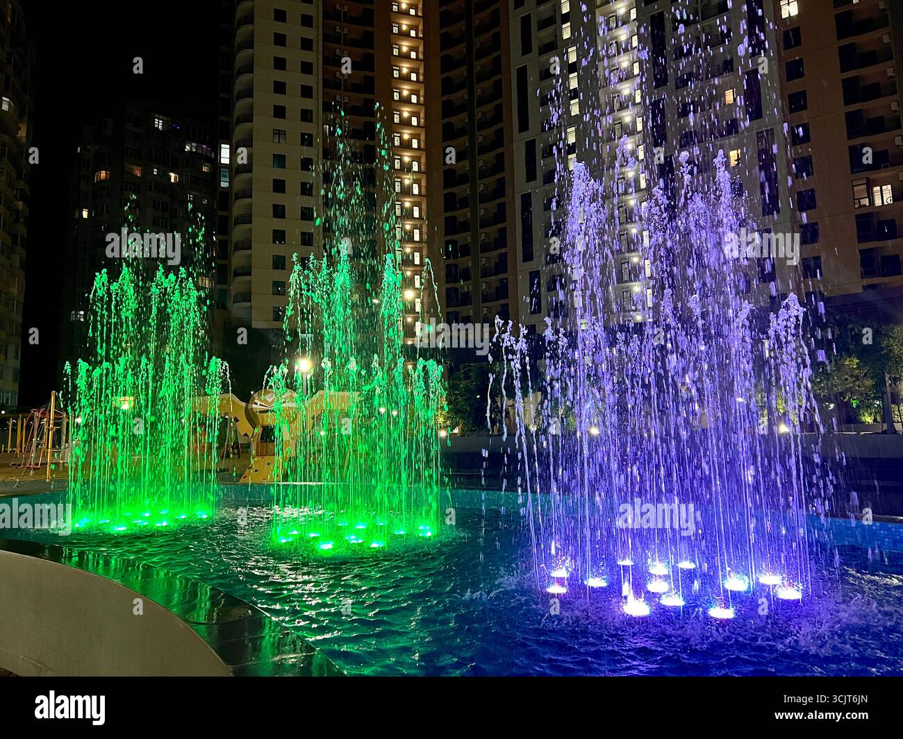 singing fountain with colored lighting in the middle of the city area - Smartphone Captured Stock Image