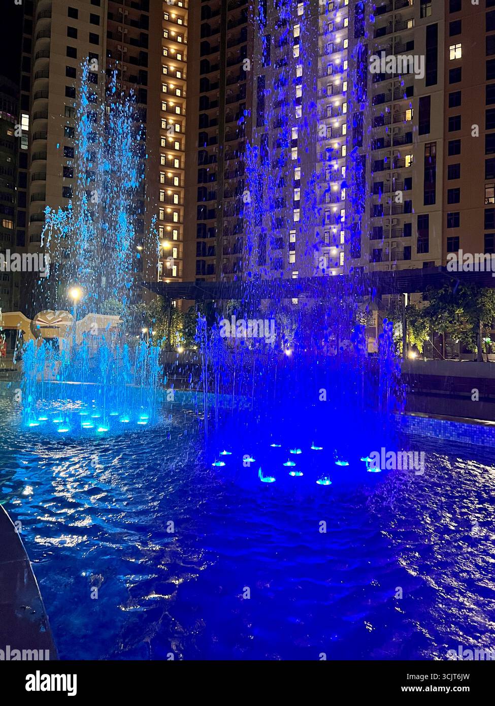 singing fountain with colored lighting in the middle of the city area - Smartphone Captured Stock Image