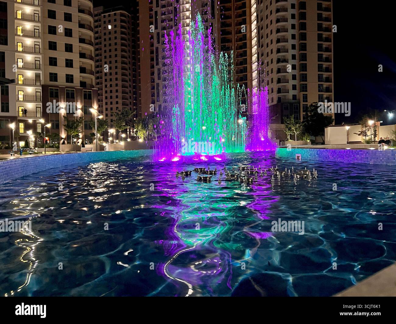 singing fountain with colored lighting in the middle of the city area - Smartphone Captured Stock Image