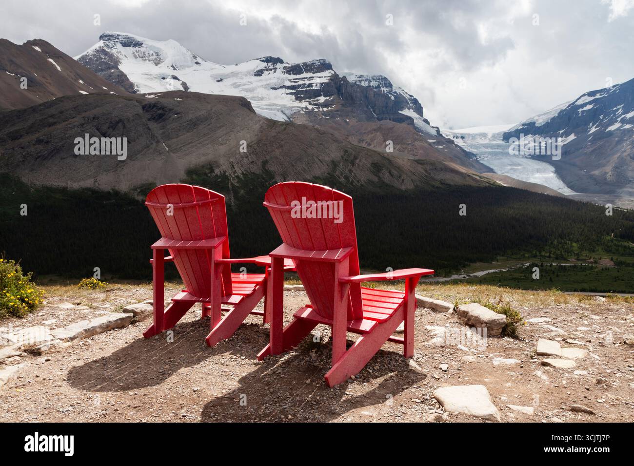 The 'red chairs overlooking the Columbia Icefield' are located on the Wilcox Pass Trail. They were placed there by  Parks Canada to offer hikers a rel Stock Photo