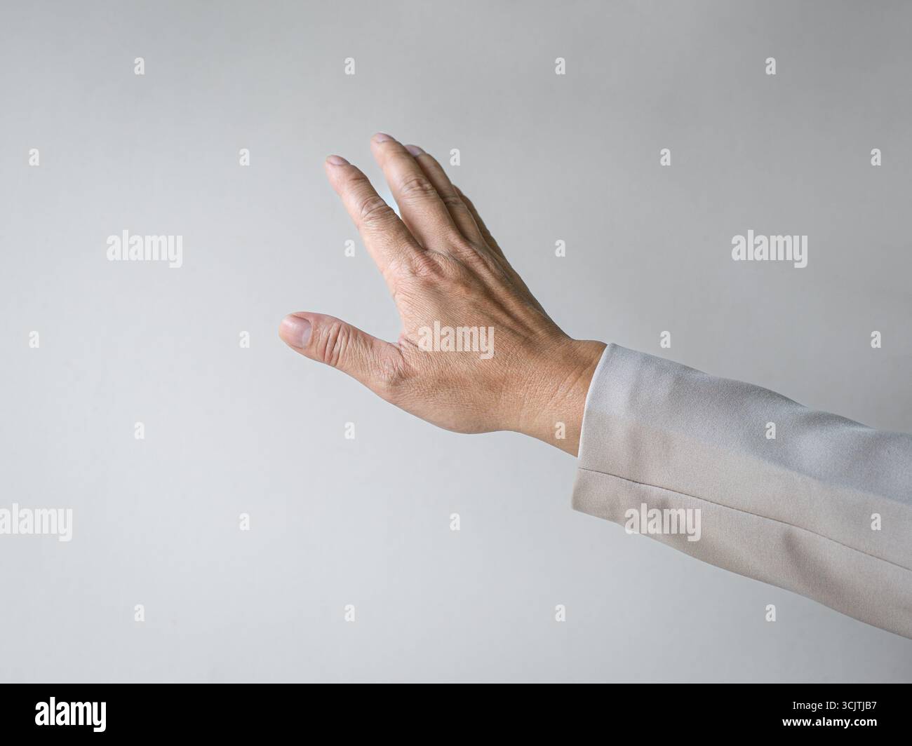 Man reaching out his hand as though touching something. Isolated on white background, copy space. Stock Photo