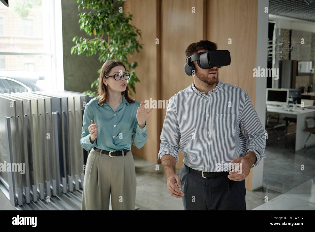 Caucasian Young Man Using Virtual Reality Headset While Young Woman Gesturing Stock Photo