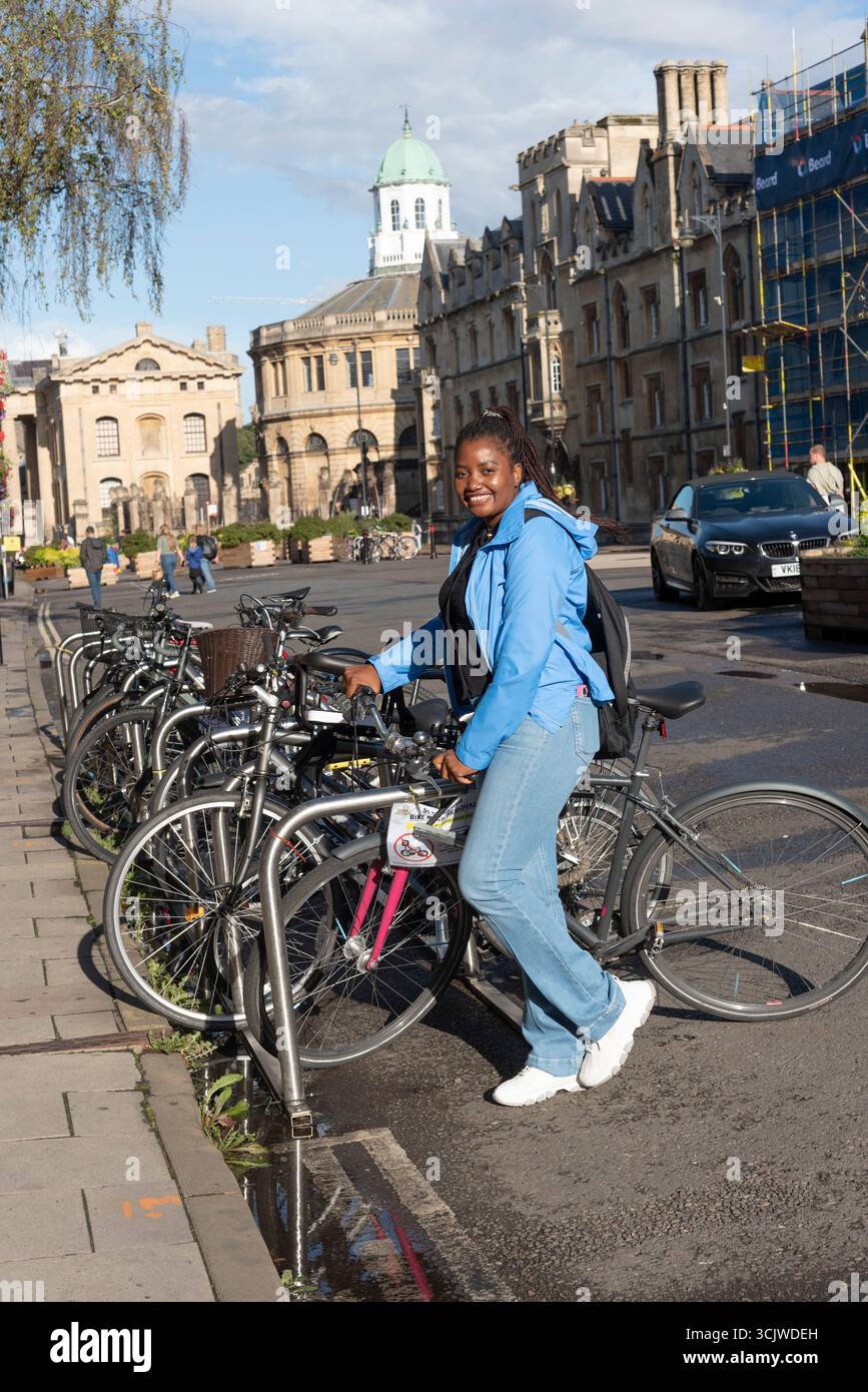 Oxford England UK. 01.09.2025. African woman touring Oxford city centre on a cycling visit to the city. Stock Photo