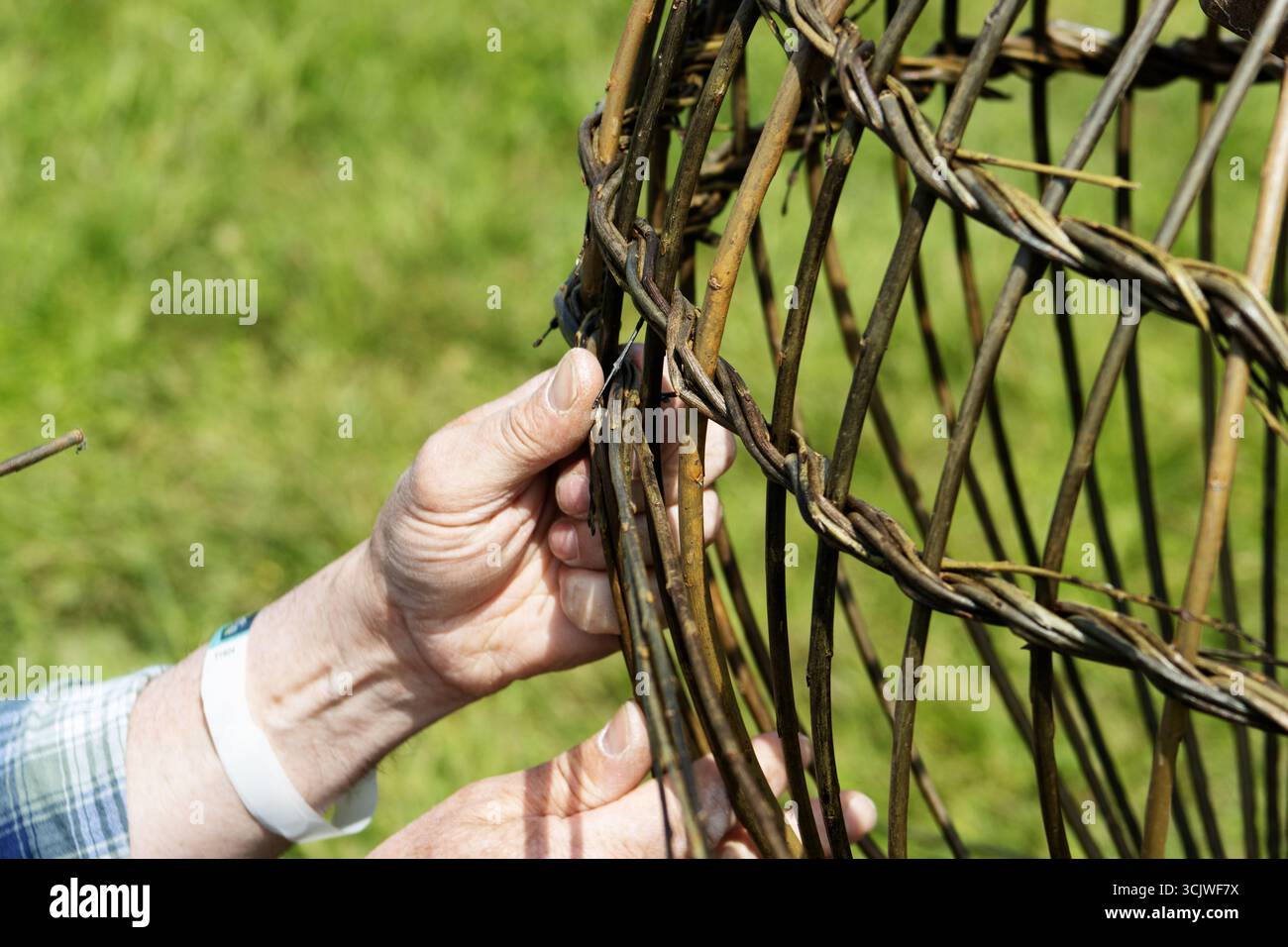 close detail of a pair of hands weaving a traditional basket Stock ...