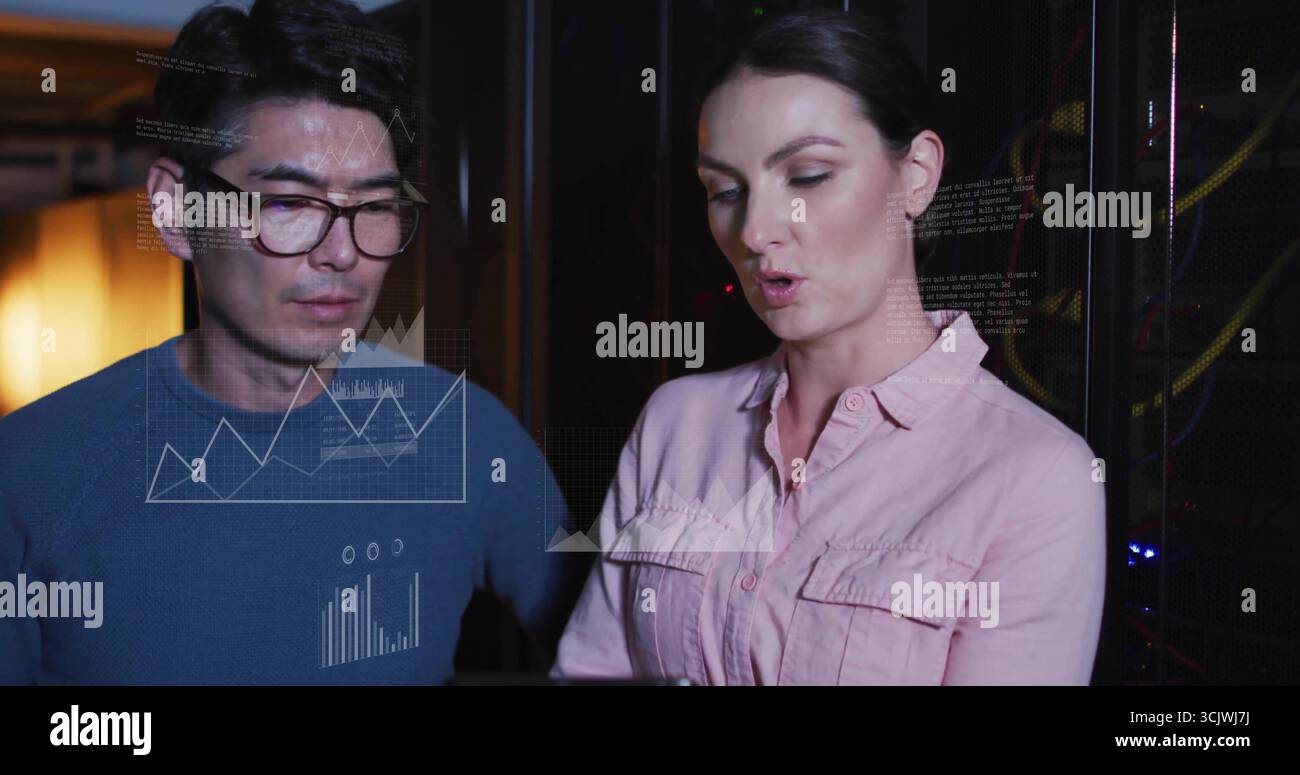 Analyzing data overlays, two IT professionals working in server room, with racks and cables Stock Photo