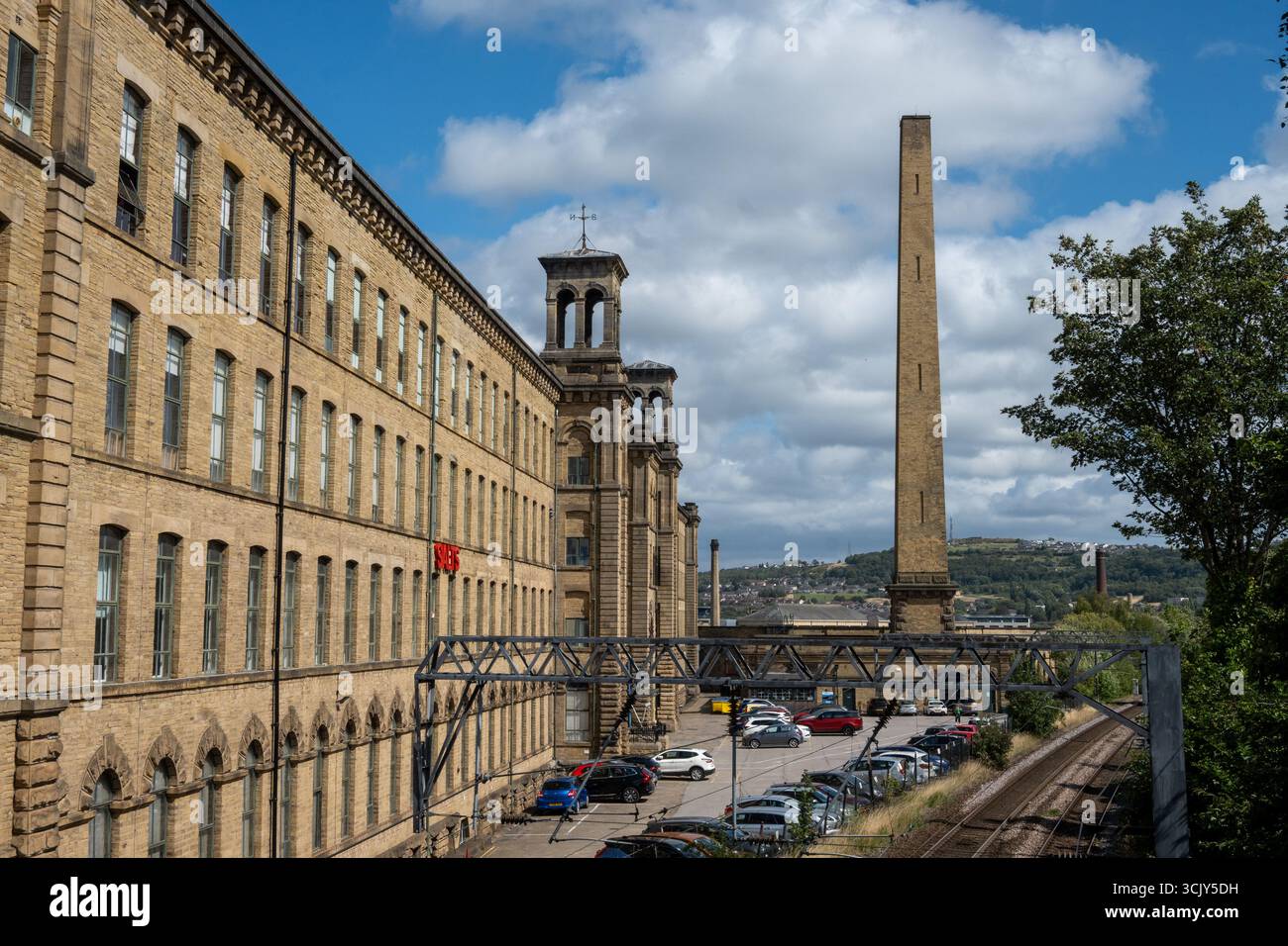 Historic Salts Mill in Saltaire, West Yorkshire, with its iconic chimney under a blue sky, a UNESCO World Heritage Site, David Hockney Centre Stock Photo