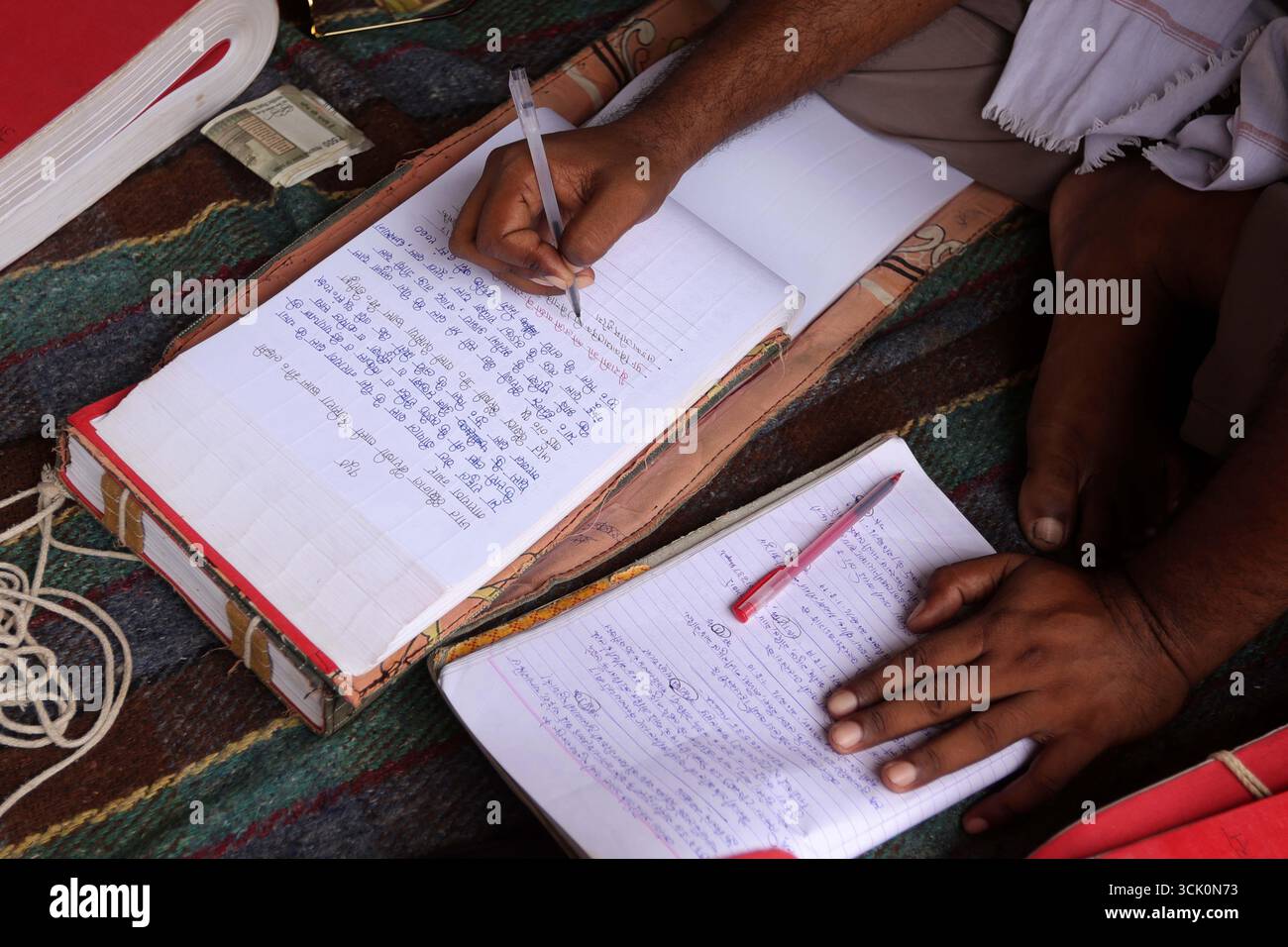 Prayagraj, India. 09 Sep. 2025, A priest prepares a record book of ...