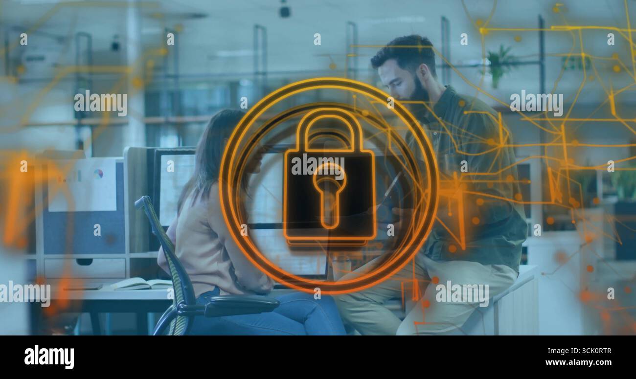 Displaying glowing orange padlock icon circling network circuits in office, data security theme Stock Photo