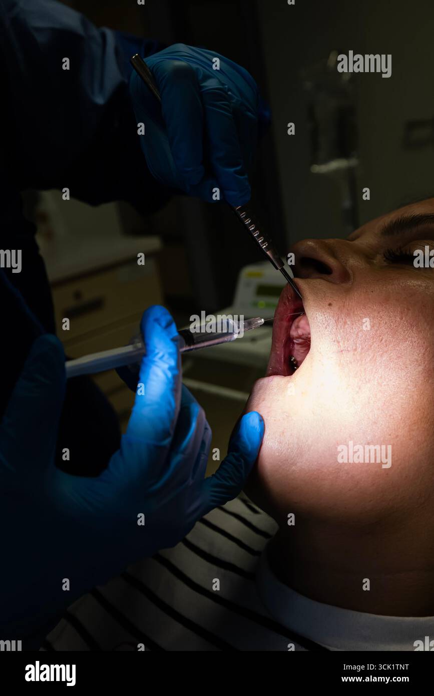 During implant treatment, a doctor performs an injection. The dentist ...