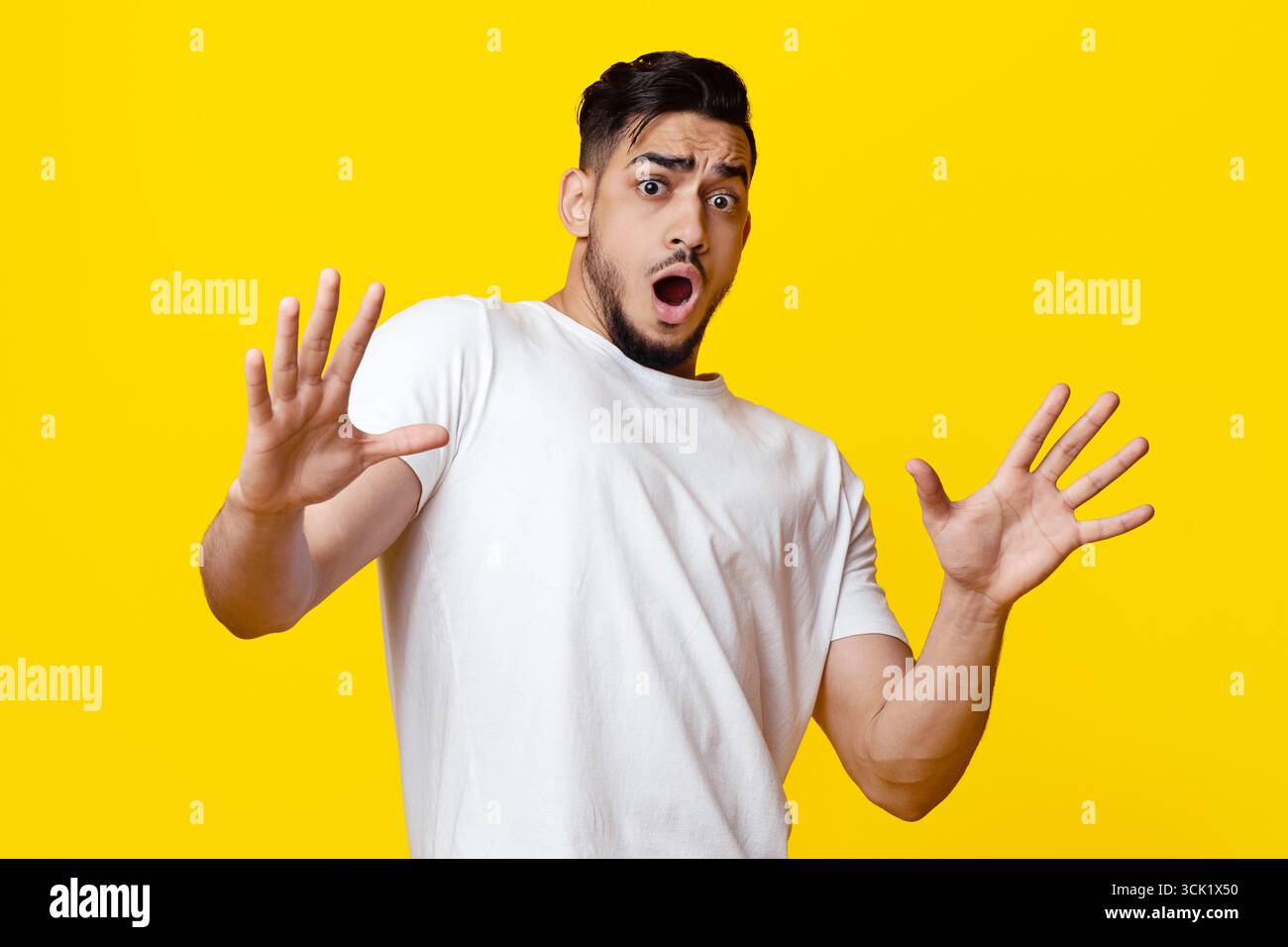 Scared arab guy in casual showing stop gesture Stock Photo